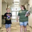 adult student that is a mom and her son walking down the BSC hall